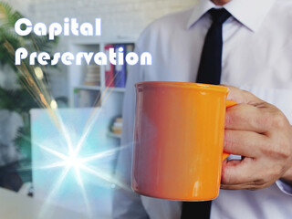 Business concept meaning Capital Preservation Man with a cup of coffee in the background.