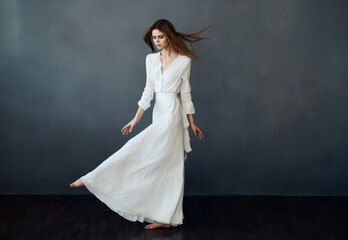 Fototapeta na wymiar Woman in white dress dance performance luxury glamor gray background