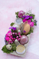 Easter decoration with colored eggs, flowers, egg box.