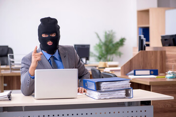 Young male employee in industrial espionage concept