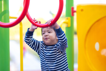 Faunny happy  3 year boy climbing on playground outdoor park