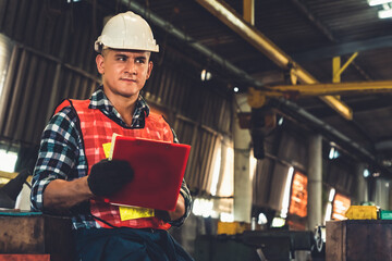 Manufacturing worker working with clipboard to do job procedure checklist . Factory production line...