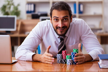 Young male employee in gambling concept