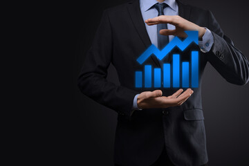 Businessman hold drawing on screen growing graph, arrow of positive growth icon.pointing at creative business chart with upward arrows.Financial, business growth concept