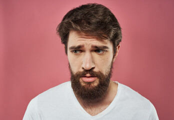 Obraz premium Man with a beard on a pink background sad face emotions model