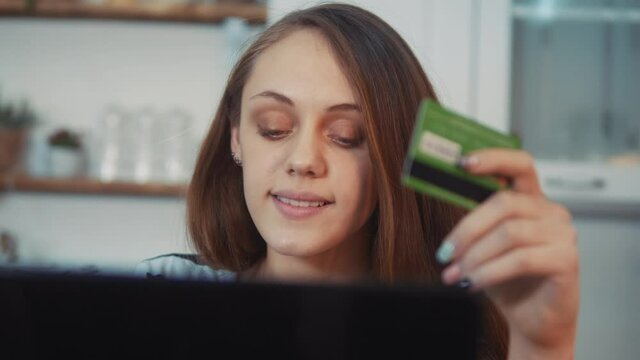 girl pays for purchases online shopping with a debit card in a smartphone. online store internet shop e-commerce concept. girl makes purchases in a web store with a debit card. online shopping
