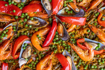 Spanish seafood paella in fry pan with mussels, shrimps and vegetables