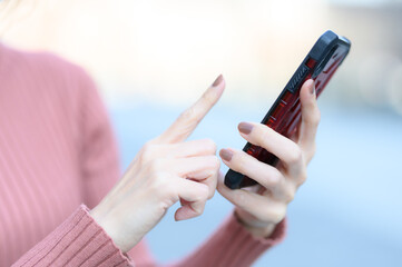 スマートフォンを操作する手元