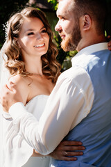 close up. Happy and beautiful bride and groom gently cuddle in park. touches.
