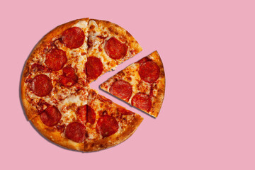 Fresh tasty pepperoni pizza on pastel pink background with copy space. 