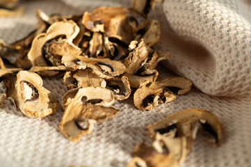 dried chopped mushrooms champignons, scattered on the table in bright daylight, blank, semi-finished product, additive for cooking