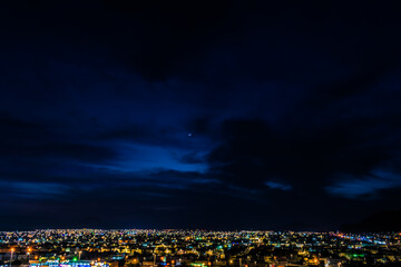 city lights with moon and sunset