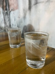 2 cold water glasses are placed on the dining table.
