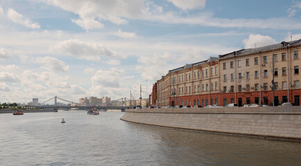 On the Moscow River sailing ships. Vehicles and people move along the waterfront