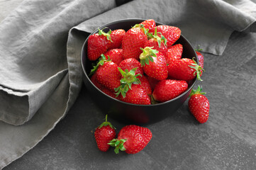 Fresh strawberries in bowl on grey