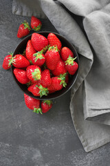 Fresh strawberries in bowl on grey