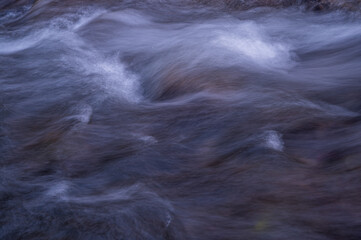 Water flowing over rocks. Long exposure. Abstract background.