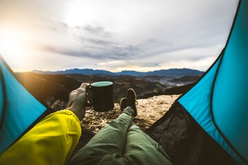 POV view of hipster tourist inside tent in front of mountains landscape  - Adventure, hiking and...