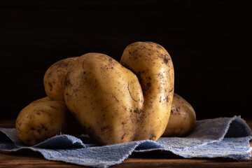 Heart shaped ugly potatoes on a dark background.