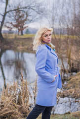 Woman in violet coat, colorful scarf, portrait of blonde nice lady at city park, trendy concept