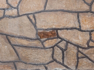 Close up color photo of an old rustic stone wall background photo with thick gray mortar and copy space.