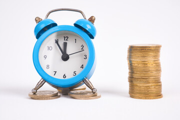 alarm clock and coins tower,investment concept, growing on coin,finance business, save money and save time