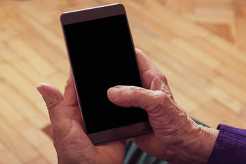 Very old woman holding cell phone. Close-up. Top view. 
