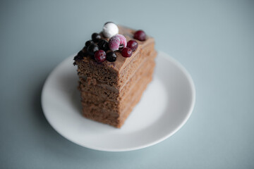 White plate with chocolate pie of homemade cake with berry decorate on top