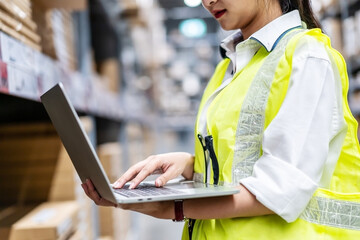 Asian engineer woman check stock details on tablet computer for checking boxes with logistics on...