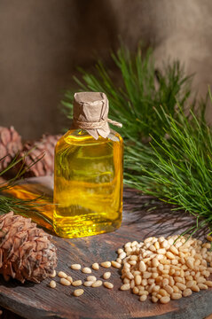 Pine Nut Oil. On A Wooden Background. Nearby Pine Nuts And Cones. View From Above.