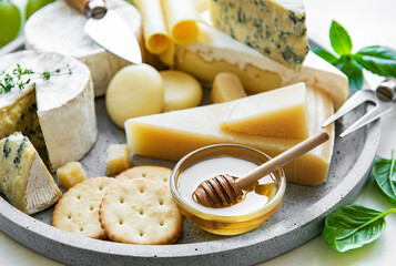Various types of cheese, grapes and honey