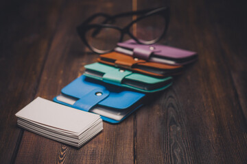 business card wallet and a pack of white paper glasses on a wooden table