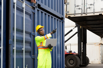 Foreman works with laptop computer radio to communicate with forklift drivers. Foreman using laptop computer in the port of loading goods.