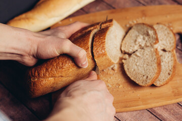 slicing fresh bread on a wooden cutting board breakfast meal