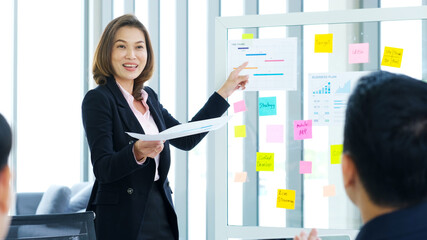 Businesswoman presenting business plan information to team at office meeting, Asian leader woman...