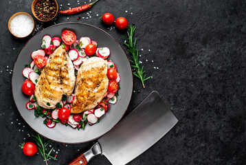 Grilled chicken breast and salad with fresh vegetables, tomatoes and radishes. Chicken meat with salad. Healthy food on stone background with copy space for your text