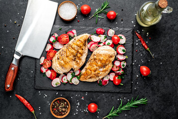 Grilled chicken breast and salad with fresh vegetables, tomatoes and radishes. Chicken meat with salad. Healthy food on stone background