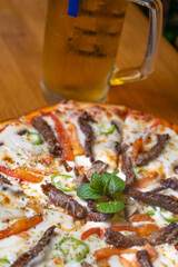 close-up meat pizza and beer