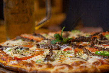 close-up meat pizza and beer