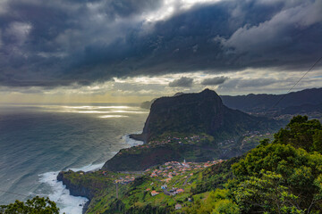 Blick auf den Adlerfelsen mit dramatischem Himmel an der Kueste Madeiras