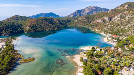 Fototapeta na wymiar Panoramic and vivid shot of Oludeniz, also known as Blue Lagoon, in Fethiye. It is located on south-west of Turkey and it has been a tourist attraction with its blue sea, weather and coast.