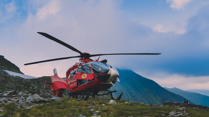 Fototapeta na wymiar Fagaras, Arges/Romania - 08/02/2020: Rescue helicopter on top of the mountain trying to land urgently to save a climber