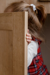 A little girl is looking for sweets in the kitchen, looking into every corner
