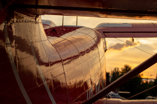 Part Of The Shiny Hull Of A Red Small-passenger Plane In Sunset Light