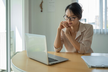 Asian businesswoman gets stressed while having a problem at work in the office.