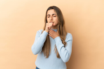 Young caucasian woman isolated on beige background coughing a lot