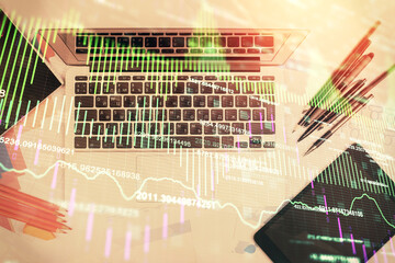 Multi exposure of forex chart drawing over table background with computer. Concept of financial research and analysis. Top view.