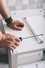 Mans hands holding a screwdriver. Furniture assembling. Housework. Vertical shot