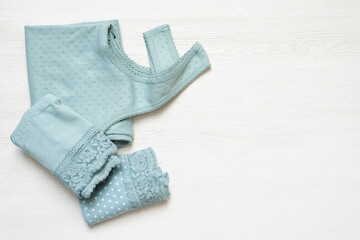 Mint color female shirt and panties on the white table background with copy space.