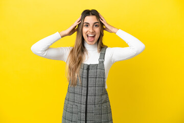 Young caucasian woman isolated on yellow background with surprise expression